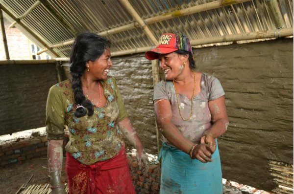 Women in a Nepali village plastering the bamboo walls with mud during the construction of their transitional homes after the 2015 earthquake.